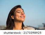 Latin woman smiles happily relaxed with her eyes closed. Copy space