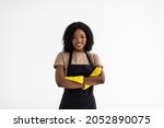 Cleaning concept. Young african woman in green apron on white background