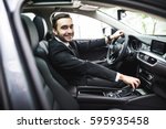 transport, business trip, destination and people concept - close up of young man in suit driving car look at camera