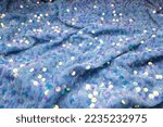 Luxurious velvet fabric embroidered with sparkling sequins. Velvet light blue fabric with sequins for sewing elegant party dresses.