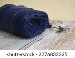 Small photo of Blue Denim Pant isolated like roll form into the table. Denim pant roll display into the wooden table. Jeans pant roll display at studio.