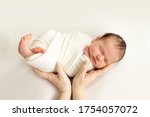 a newborn baby sleeps sweetly in his mother's arms on a white background, swaddling the baby, a place for text.