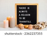 Small photo of Felt letter board and text there is always a reason to be thankful. Autumn table decoration. Interior decor for thanksgiving and fall holidays with handmade pumpkins, candles