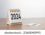 Small photo of 2024 Happy New year background. Turns over a calendar sheet. Setup objective target business cost and budget planning of new year concept. year change from 2023 to 2024.