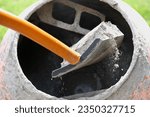 Small photo of Construction site. Adding lime, sand and stones to rotating cement mixer. Builder working with shovel during concrete solution mortar preparation. Bricklayer job machine equipment. Cement slurry