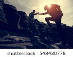 Couple hiking help each other silhouette in mountains with sunlight