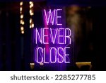 Purple neon light inside a restaurant stating: 