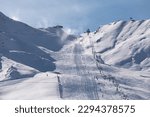 Small photo of Ski lifts heading toward the top of the snow-capped mountains of Grandvalira from Pas de la Casa.