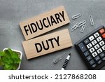 Small photo of Fiduciary duty text on wooden blocks on a gray background