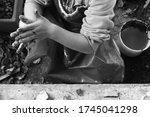 Small photo of Dirty hands of a little girl in black and white Poor child painting and playing with paint Wench with unclean fingers
