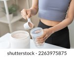 Diet meal replacement for weight loss, asian young woman in sportswear, hand in holding scoop making protein into bottle to shake, drink supplement for muscle after workout at home. Healthy body care.