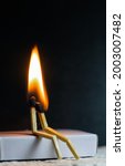 Small photo of Two matches burning sitting together on the matchbox in the dark copy space. Two matches in flame as a metaphor of togetherness friendship, Love And Romance Concept. Matchstick art photography.