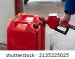 A Man Fills Jerry Cans At A Gas ...
