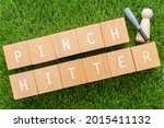 Small photo of PINCH HITTER; Wooden blocks with "PINCH HITTER" text of concept, a human toy, and a baseball bat toy.
