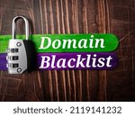 Small photo of Top view padlock and colored ice cream stick with text Domain Blacklist on wooden background.