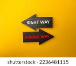 Arrow wooden board with the word RIGHT WAY WRONG WAY on yellow background.