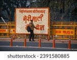Small photo of New Delhi, India-Nov 1 2023: man passing from flower made decorated Welcome board 'Meri Mati Mera Desh' campaign