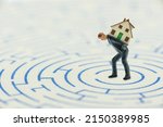 Small photo of Improving financial situation and break the debt cycle for good, financial concept : Client or a debtor is trapped in a maze or labyrinth with a model house and attempts to escape from a bad debt trap