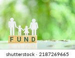 Small photo of Private family foundation and charitable fund for families, financial concept : Family, a father, a mother with two children stand on wood cubes with the word FUND, depicting charitable activities.