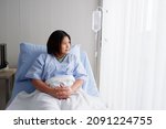 Small photo of A female patient lying on the patient's bed ready to give saline, showing symptoms of depression, delusion.