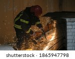 Small photo of Firefighters trying to cut trough venthole with grinder to get the smoke out of people's apartments. Translation: ''Firefighters Rescuers''