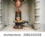 Small photo of Bangalore, Karnataka, India-November 20 2021;A Divine picture of a Shivlingam in black stone with a copper vessel on top to anoint the deity with milk for Shivrathri festival in a Bangalore, India.