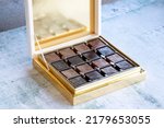 Small photo of Special chocolate. Packed chocolate on stone background. Milky and bitter square shape chocolate Madlen. close up