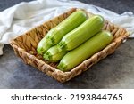 Organic zucchini. Fresh zucchini in basket on dark background. Vegetable, healthy vegan food. close up