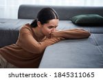 Do not touch me. Negative delighted woman laying with head on the sofa and crying while feeling bad. Depression and bad mood concept