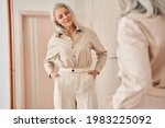 Woman looking at the mirror at her reflection while trying on new clothes
