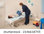 Doctor palpates the baby's stomach, girl laying at the hospital bed