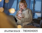 Small photo of Portrait of lady with piteous face watching video on laptop. She is sitting and eating marshmallow. Copy space in left side