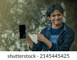 Small photo of An indian boy holding phone for advertising. Templet for advertisement.