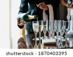 Waitress pouring champagne in multiple glasses