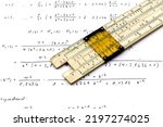 Small photo of vintage slide rule being used for calculation with technical formula and a piece of paper
