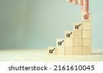 Small photo of Corporate regulatory and compliance. Goals achievement and business success. Project and goals tracking. Task completion. Managing project timeline. Holding wooden cube with target achievement icon.