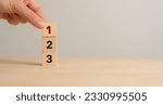 Small photo of Task priority and management concept. The order of priority in any activity. Set work priority, arrange to do list. Wooden cube blocks with number first, second and third.