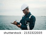 African American seaman filling checklist during work