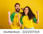 Small photo of couple of brazil soccer supporters, dressed in the colors of the nation, black woman, caucasian man. Twisting and vibrating.