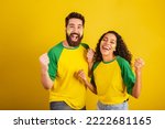 Small photo of couple of brazil soccer supporters, dressed in the colors of the nation, black woman, caucasian man. Twisting and vibrating.