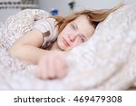 Portrait of a worried young woman in bed can not sleep a headache. Health Wellness