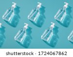 Trendy pattern with antiseptic. Bottle of instant antiseptic hand sanitizer transparent gel isolated on blue background, no label. Antibacterial, hydro alcoholic gel, e