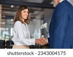 Small photo of Mature Latin business team of woman and European business man shaking hands as colleagues, partners or employees, signing a contract. Group of people satisfied with results of team work together.