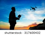 man playing with the drone. silhouette against the sunset sky