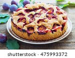 Small photo of rustic plum cake on dark wooden background