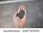 Small photo of View of the circular steel grits in the palm for abrasive or sandblasting. Steel grits are produced by fracturing high carbon steel balls after heat treatment. Steel grits have high resistance.