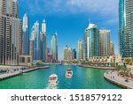 Luxury Dubai Marina skyscrapers, cruise boat and promenade in beautiful summer morning, Dubai, United Arab Emirates