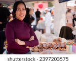 Small photo of Close-up of a woman crossing her arms offering dairy products and almojabanas at a gastronomic fair. Concept of typical Colombian food.