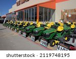 Small photo of Austin, Texas – 29 January 2022: John Deere riding lawn mowers and tractor in broad daylight