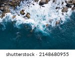 Aerial view Top down seashore big wave crashing on rock cliff Beautiful blue sea surface in sunny day summer background Amazing seascape top view seacoast at Phuket Thailand
